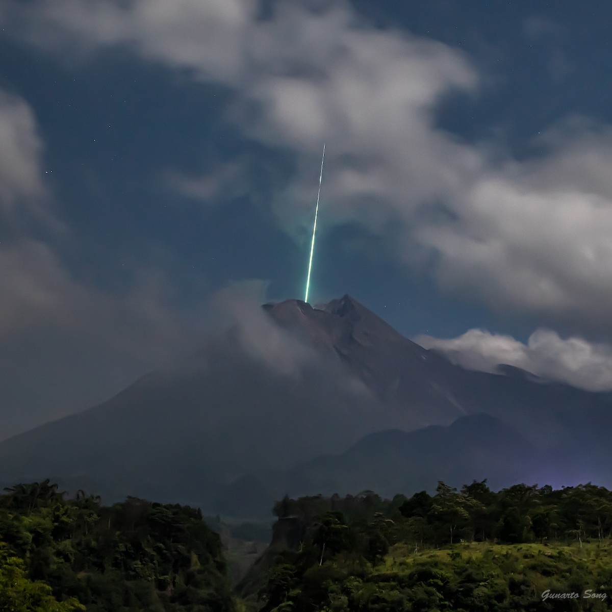 foto di una stella cadente che si getta nel cratere del Monte Merapi